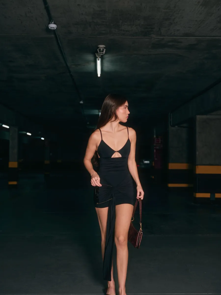 Beatriz de vestido preto em uma garagem, capa do post no Instagram