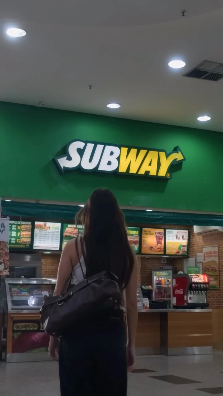 Beatriz em frente a uma loja Subway